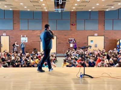 Ray speaking in front of students at assembly