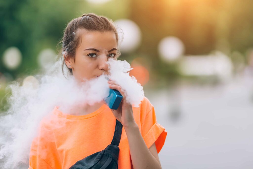 girl-wearing-orange-shirt-vaping