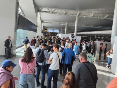 Large airport security line with travelers waiting during Ray Lozano’s national drug-prevention speaking travel.