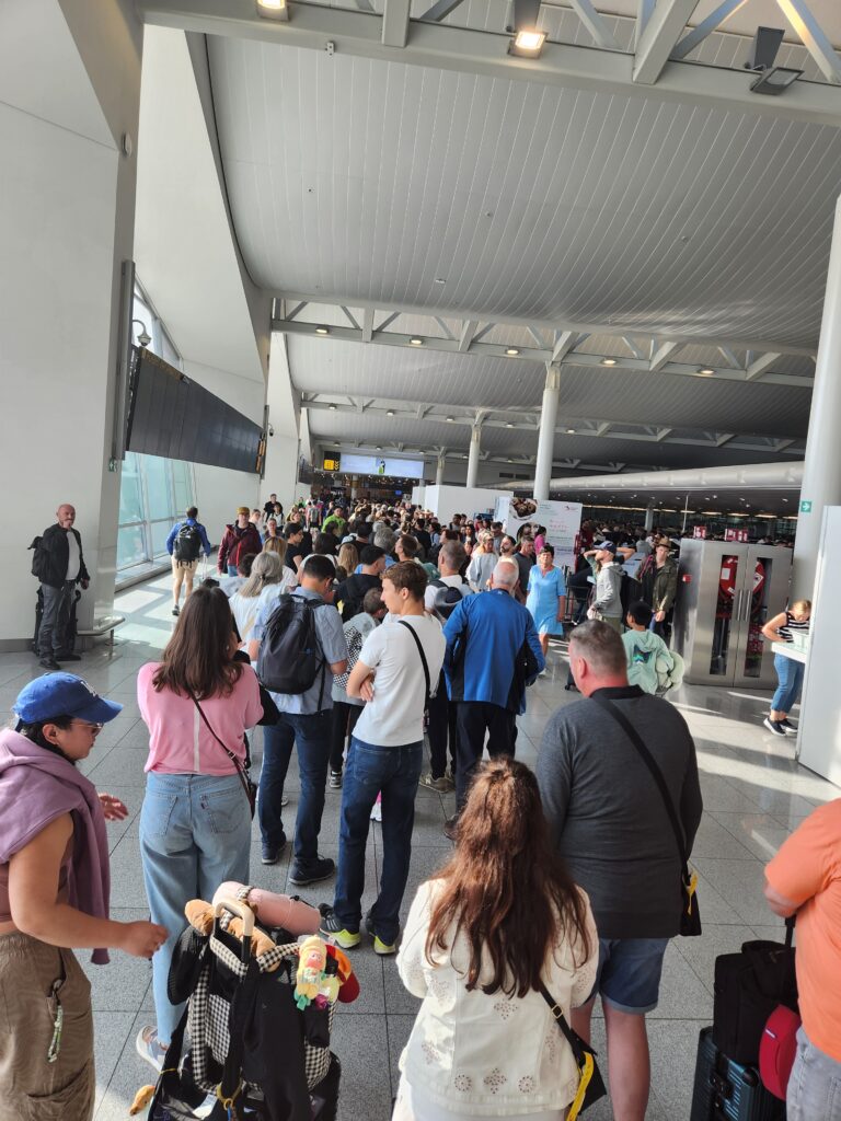 Large airport security line with travelers waiting during Ray Lozano’s national drug-prevention speaking travel.
