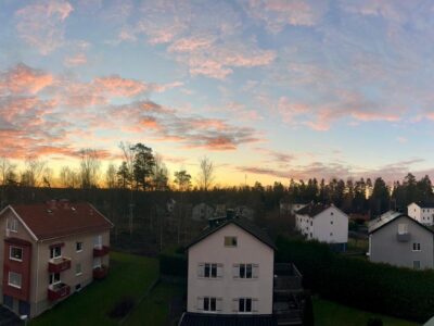 Sunrise over a quiet residential neighborhood in Sweden, with family homes, winter trees, and a colorful morning sky symbolizing reflection and preparation.